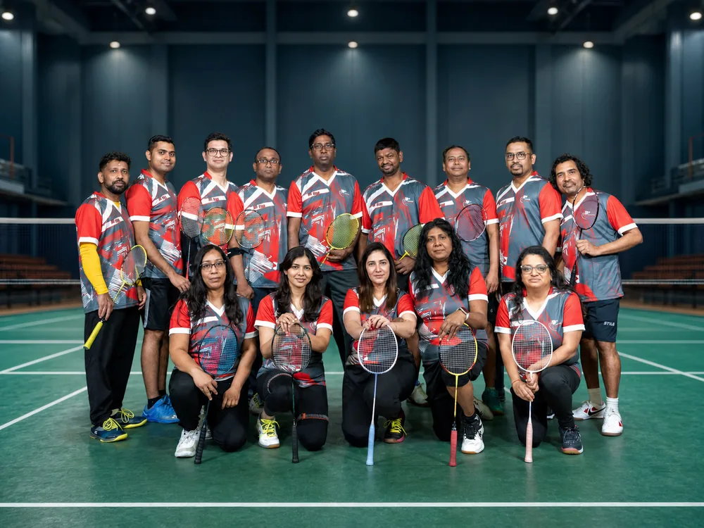 Team in red and grey jerseys posing on court